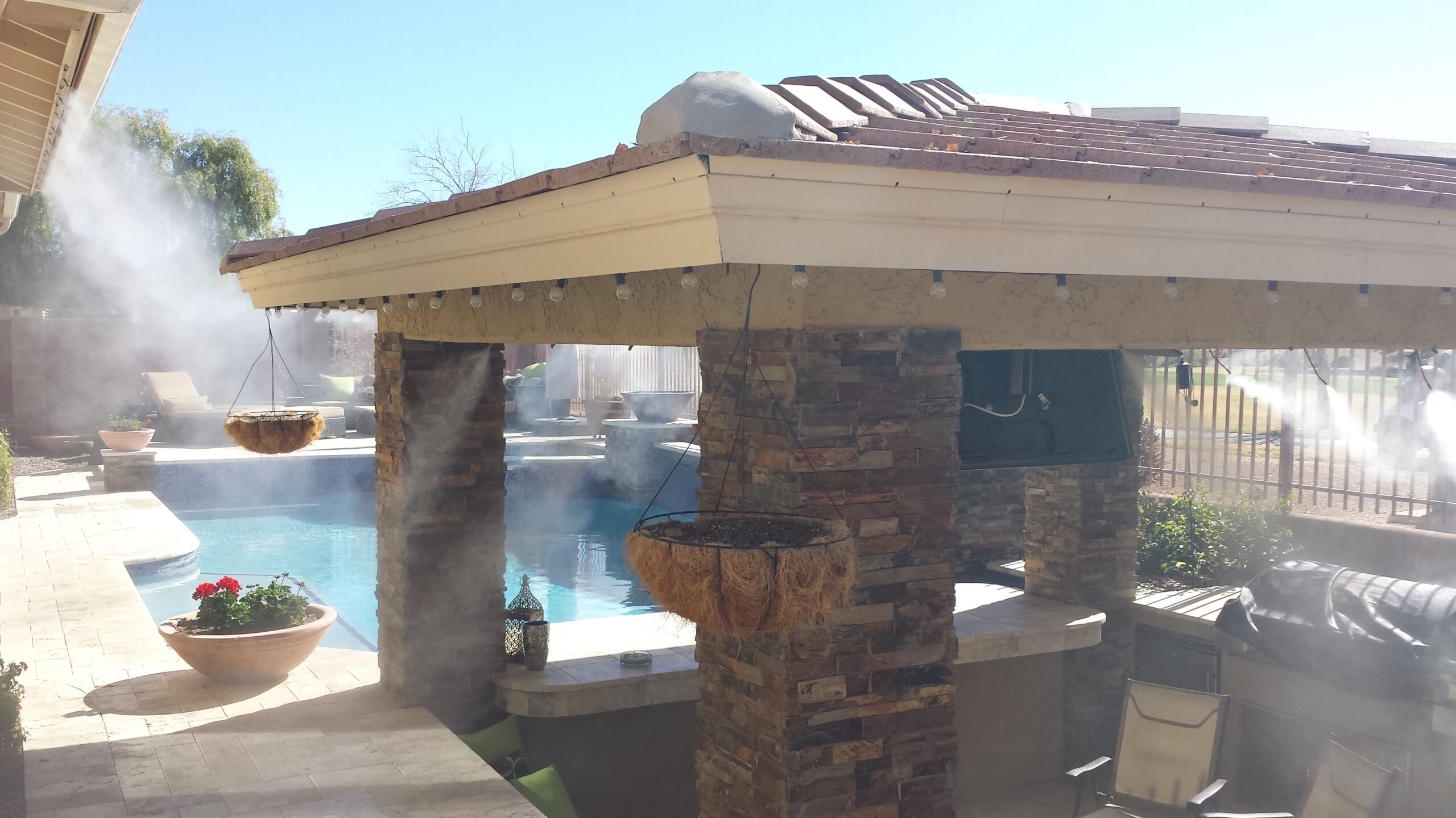 A covered patio with a pool in the background.