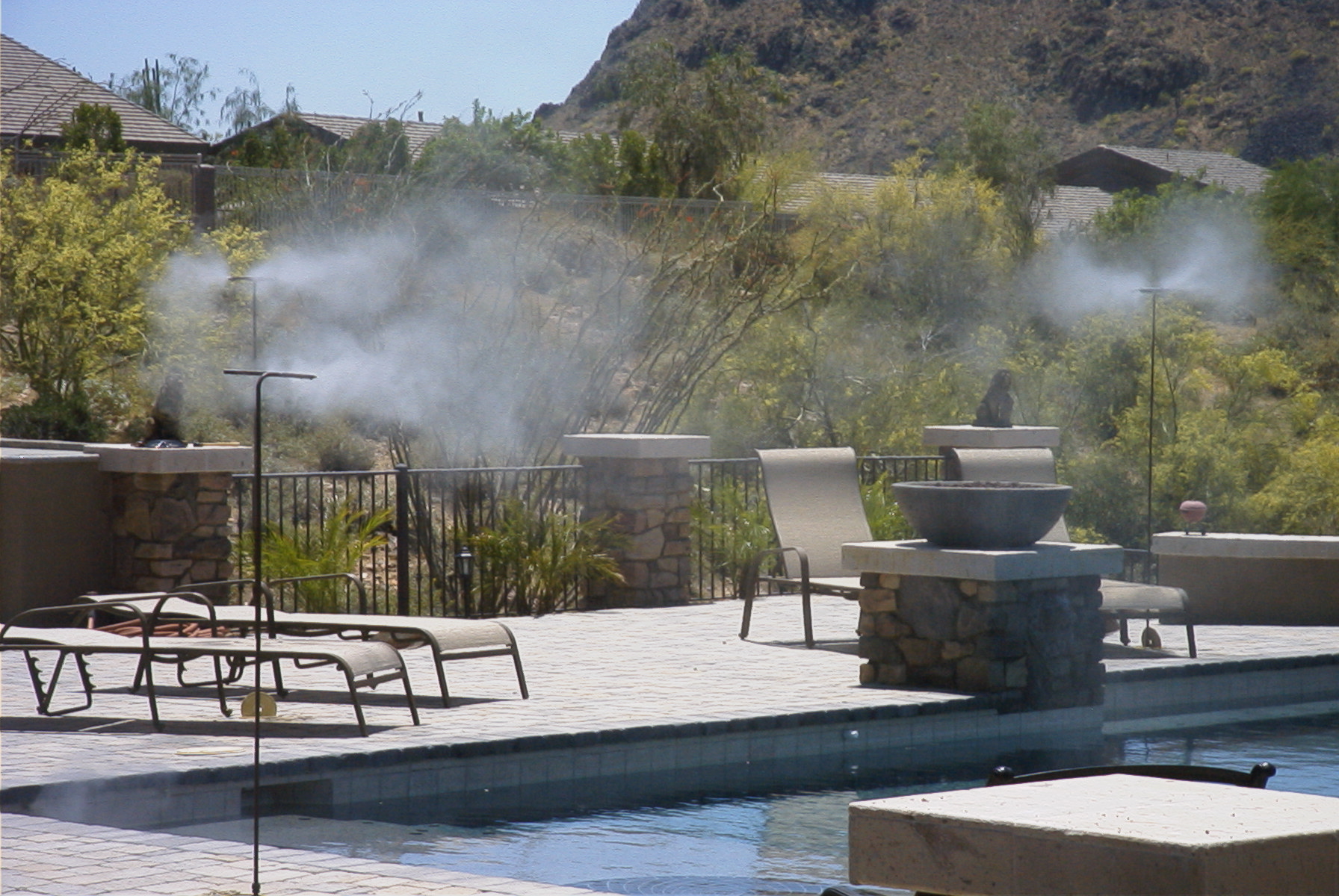 A pool with chairs and a fire pit in the middle of it.